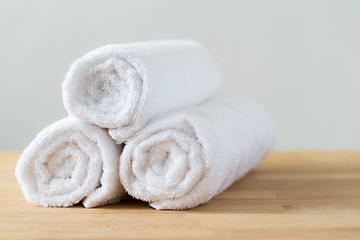 Image showing White spa towels pile on wooden table