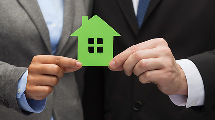 Image showing businessman and businesswoman holding green house