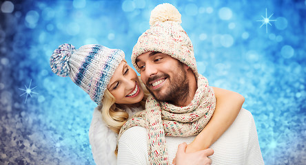 Image showing happy couple in winter clothes hugging over lights