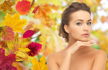 Image showing beautiful woman touching her face over autumn