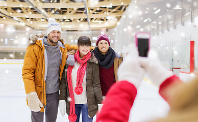 Image showing happy friends taking photo on skating rink