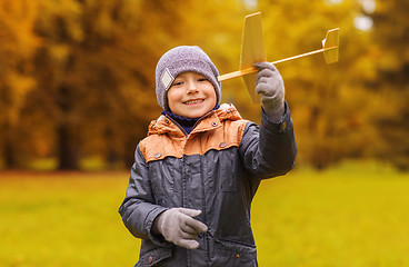 Image showing happy little boy playing with toy plane outdoors