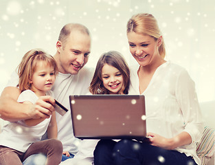 Image showing happy family with laptop computer and credit card