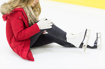 Image showing young woman with knee trauma on skating rink