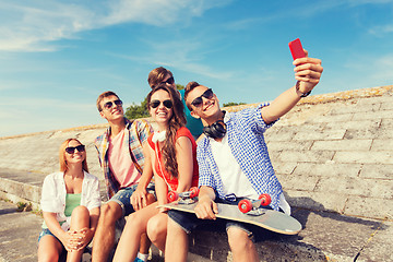 Image showing group of smiling friends with smartphone outdoors