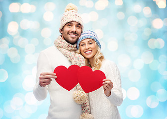 Image showing smiling couple in winter clothes with red hearts