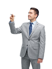 Image showing happy businessman in suit writing something