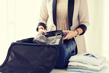 Image showing woman packing formal male clothes into travel bag