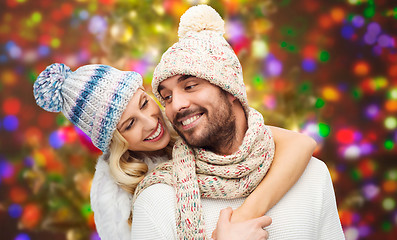 Image showing happy couple in winter clothes hugging over lights