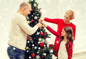 Image showing smiling family decorating christmas tree at home