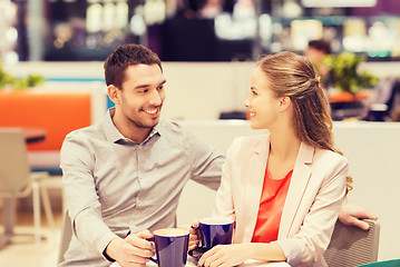 Image showing happy couple with shopping bags drinking coffee