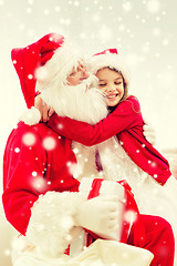 Image showing smiling girl with santa claus and gift at home