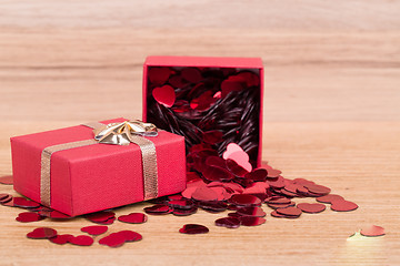 Image showing Red hearts confetti on wooden background