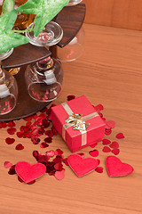 Image showing glass of vine, red hearts and small present