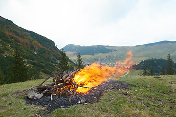 Image showing hiking man prepare tasty sausages on campfire