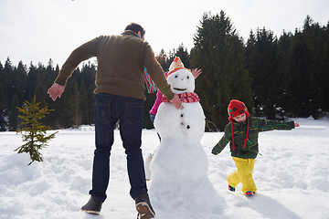 Image showing happy family building snowman