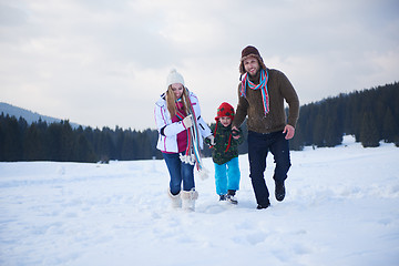 Image showing happy family playing together in snow at winter