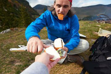 Image showing hiking man slice tasty cheese on picnic