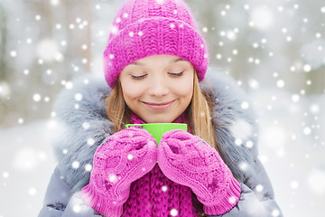 Image showing smiling young woman with cup in winter forest