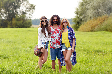 Image showing smiling young hippie friends on green field