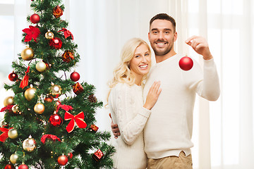 Image showing happy couple decorating christmas tree at home