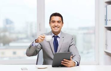 Image showing smiling businessman with tablet pc and coffee cup