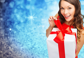 Image showing smiling woman in red dress with gift box