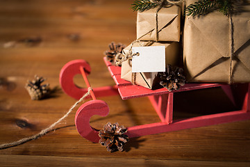 Image showing close up of christmas gifts with note on sleigh