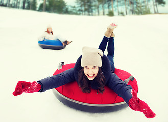 Image showing group of happy friends sliding down on snow tubes