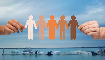 Image showing hands holding people pictogram over boats in sea