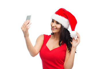 Image showing woman in santa hat taking selfie by smartphone