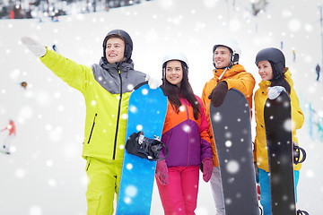 Image showing happy friends in helmets with snowboards