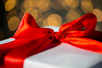 Image showing close up of christmas gift with bow over lights
