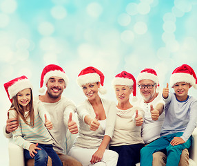 Image showing happy family in santa hats showing thumbs up