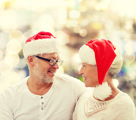 Image showing happy senior couple in santa helper hats