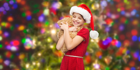 Image showing smiling girl in santa helper hat with teddy bear