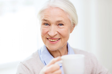 Image showing happy senior woman with cup of tea or coffee