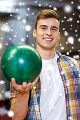 Image showing happy young man holding ball in bowling club