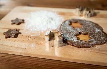 Image showing close up of ginger dough, molds and flour on board