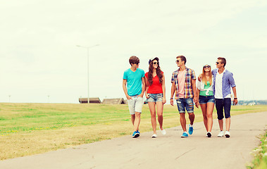 Image showing group of smiling teenagers walking outdoors