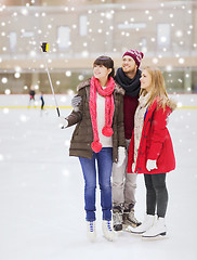 Image showing happy friends with smartphone on skating rink
