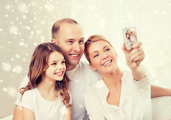 Image showing happy family with camera taking picture at home