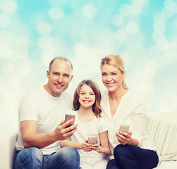 Image showing happy family with smartphones