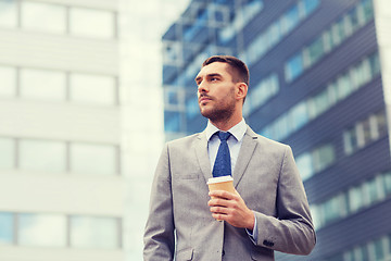 Image showing young serious businessman with paper cup outdoors