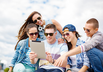 Image showing group of smiling teenagers looking at tablet pc