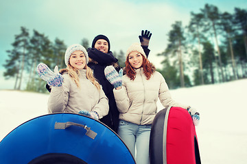 Image showing group of smiling friends with snow tubes