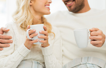 Image showing close up of happy couple with tea cups at home