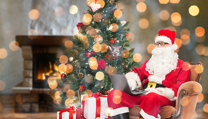 Image showing santa claus with laptop in armchair at home