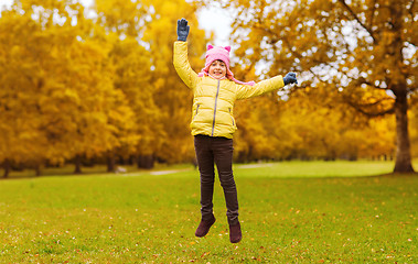 Image showing happy little girl jumping outdoors