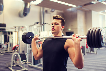 Image showing young man flexing muscles with barbell in gym